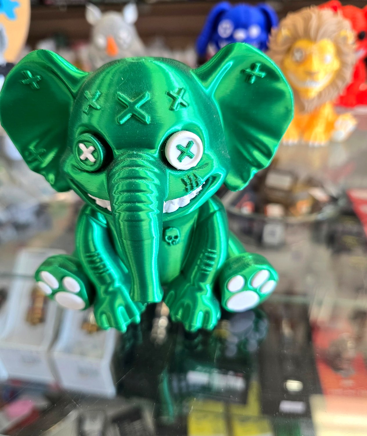 Patchwork elephant in metallic green with a stitched skull over its heart